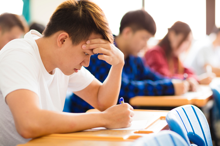 Stressed college student  for exam in classroom