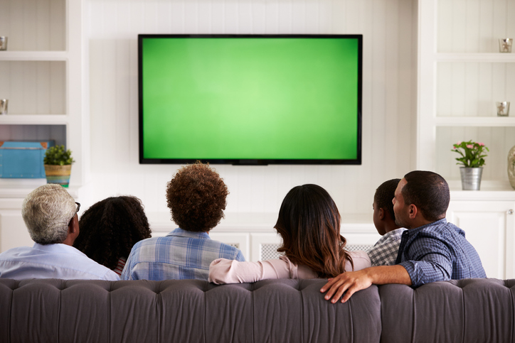 Multi generation family watching TV at home, back view